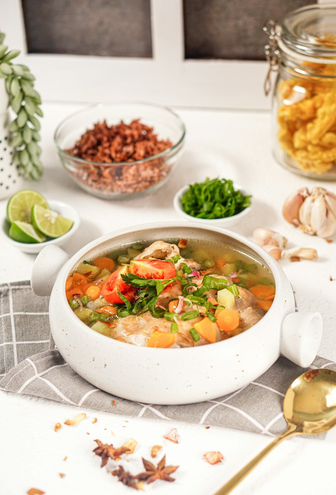 Bowl of soup with fresh herbs on a kitchen table